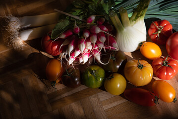 Different colorful organic vegetables from the local farmer market on old rustic wooden surface.  Seasonal vegetables background. Healthy eating, simple lifestyle in country home concepts.