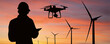 © scharfsinn86 - Silhouette of engineer with tablet computer, drone and wind turbines at sunset