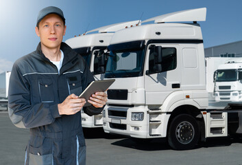 Poster - Manager with a digital tablet next to trucks. Fleet management	