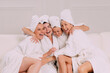 © MZaitsev - A group of women spend leisure time. Young attractive females in bathrobes chat merrily.