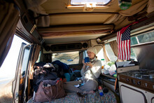 A Young Woman Takes Her Morning Coffee Inside A Volkswagen Wesfalia Camper Van On The Pacific Coast In Southern Oregon