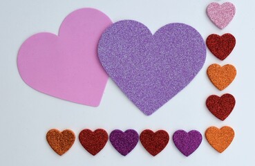 Valentines Day border of colorful paper hearts over a white background