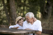 © Maria - Happy senior man Grandfather with cute little boy grandson playing in forest