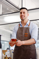 Wall Mural - Smiling cafe worker holding a cup of coffee coffee shop concept.