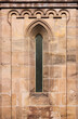 Pointed gothic window and romanesque round arch frieze at the medieval hospital church in the old town of Heilsbronn in Franken region, Germany