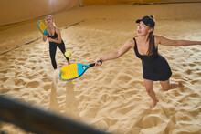 Two Women Are Passionate About Playing Beach Tennis Indoors With Sand