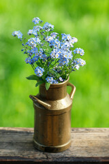 Wall Mural - Bouquet of forget-me-not flowers in old vase.