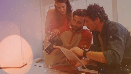 Poster - Animation of spots of light over diverse team of photographers discussing holding digital camera