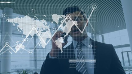 Wall Mural - Animation of graphs and map over biracial businessman talking on cellphone at office