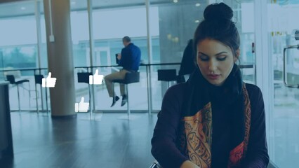Poster - Animation of thumbs up icons over caucasian woman drinking coffee and using laptop at cafeteria