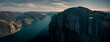 Panorama landscape of Preikestolen rock with view into Lysefjord in Norway, steep cliff in the mountains with a platform, sunny day with blue water in the fjord