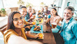 © Davide Angelini - Multiracial group of friends having dinner party sitting at coffee bar table
