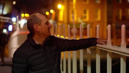 Wall Mural - Young Man standing on the Ha Penny Bridge in Dublin - Ireland travel photography