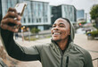 © S Fanti/peopleimages.com - Phone selfie, fitness and black man in city taking picture for social media or happy memory outdoors in winter. Sports, training and male runner with 5g mobile smartphone taking a photo on street.