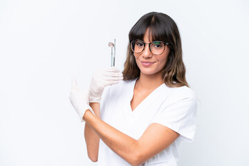 Canvas Print - Dentist caucasian woman holding tools isolated on white background pointing back