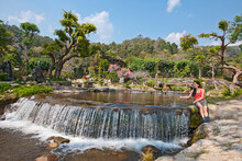 Woman Sitting At A Waterfall By A Small Pond In Northern Thailand