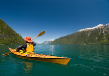 A Woman Kayaks In Lago Yelcho, Chile.
