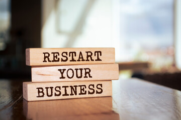 Wall Mural - Wooden blocks form the words 'restart your business' on blur background. Business concept.