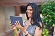 © Krakenimages.com - Middle age hispanic woman smiling confident using touchpad at street