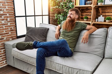 Poster - Young redhead man smiling confident sitting on sofa at home