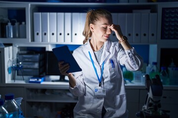 Poster - Beautiful blonde woman working at scientist laboratory late at night tired rubbing nose and eyes feeling fatigue and headache. stress and frustration concept.