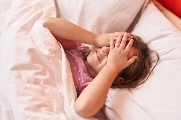 Wall Mural - Adorable hispanic girl stressed with hands on eyes lying on bed at bedroom