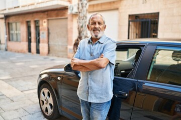 Wall Mural - senior grey-haired man smiling confident standing with ars crossed gesture by car at street
