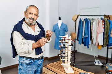 Poster - Senior grey-haired man smiling confident holding glasses at clothing store