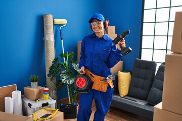 Canvas Print - Young hispanic technician working at home renovation smiling with a happy and cool smile on face. showing teeth.