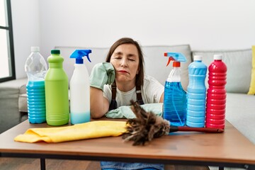 Wall Mural - Middle age hispanic woman working as housekeeper tired of cleaning at home