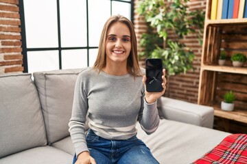 Poster - Young woman holding broken smartphone showing cracked screen looking positive and happy standing and smiling with a confident smile showing teeth