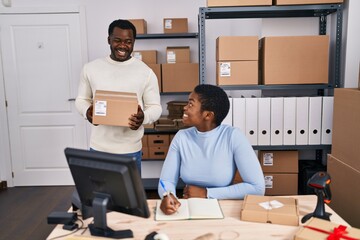 Canvas Print - Man and woman ecommerce business workers writing on notebook at office