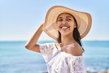 Young african american woman tourist smiling confident wearing summer hat at seaside