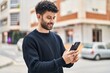 © Krakenimages.com - Young arab man smiling confident using smartphone at street