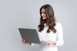 © Olena - Cheerful business woman standing over grey wall with laptop computer. Portrait of pretty, charming, stylish, clever woman with open laptop chatting, using internet, isolated on grey background.