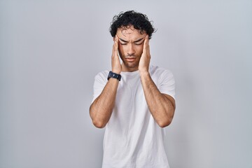 Wall Mural - Hispanic man standing over isolated background with hand on head, headache because stress. suffering migraine.