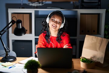 Wall Mural - Young asian woman working at the office with laptop at night happy face smiling with crossed arms looking at the camera. positive person.