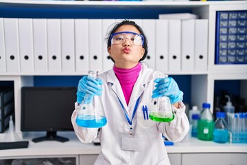 Sticker - Young asian woman working at scientist laboratory looking at the camera blowing a kiss being lovely and sexy. love expression.