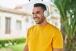 © Krakenimages.com - Young hispanic man listening to music standing at park