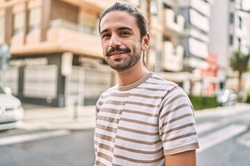 Wall Mural - Young hispanic man smiling confident at street