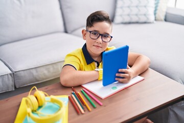 Sticker - Adorable hispanic boy using touchpad sitting on floor at home