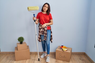 Sticker - Young hispanic woman painting home walls with paint roller looking sleepy and tired, exhausted for fatigue and hangover, lazy eyes in the morning.