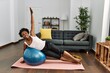 © Krakenimages.com - African american woman training abs exercise using fit ball at home