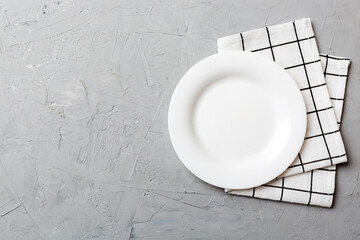 Top view on colored background empty round white plate on tablecloth for food. Empty dish on napkin with space for your design