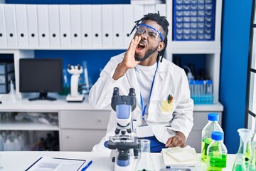 Wall Mural - African man with dreadlocks working at scientist laboratory clueless and confused with open arms, no idea and doubtful face.