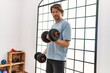 © Krakenimages.com - Middle age caucasian man training using dumbbells at sport center