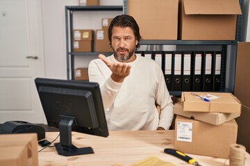 Canvas Print - Handsome middle age man working at small business ecommerce looking at the camera blowing a kiss with hand on air being lovely and sexy. love expression.