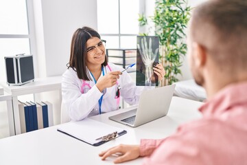 Wall Mural - Man and woman doctor and patient having medical consultation holding xray at clinic