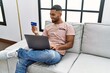 © Krakenimages.com - Young arab man using laptop and credit card at home