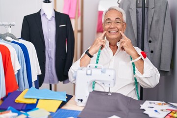 Sticker - Middle age man with grey hair dressmaker using sewing machine smiling with open mouth, fingers pointing and forcing cheerful smile